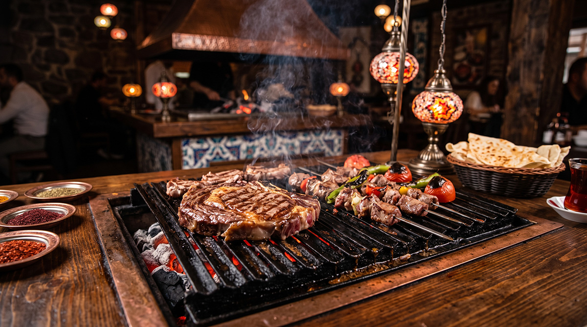 Steak en premium vlees worden gegrild op de tafelbarbecue bij Salt & Pepper, steakhouse in Eindhoven.